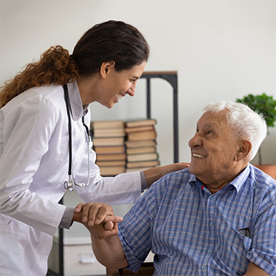 doctor talking to a seated elderly man